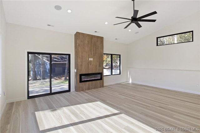 unfurnished living room featuring a fireplace, light wood finished floors, visible vents, vaulted ceiling, and baseboards