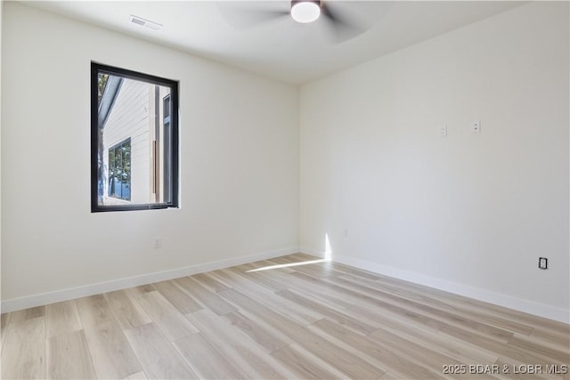 unfurnished room featuring light wood-style floors, visible vents, baseboards, and a ceiling fan