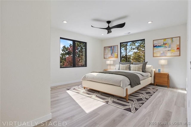 bedroom featuring light wood-type flooring, multiple windows, baseboards, and recessed lighting