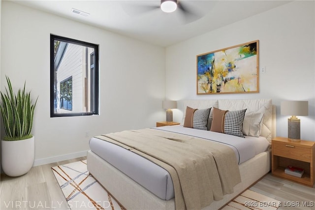 bedroom with a ceiling fan, baseboards, visible vents, and wood finished floors