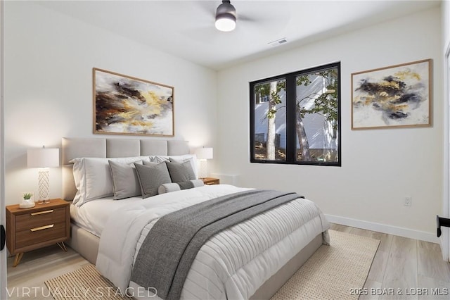 bedroom with light wood finished floors, baseboards, visible vents, and a ceiling fan