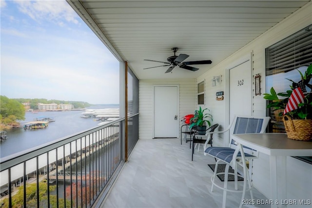 balcony featuring a water view and ceiling fan