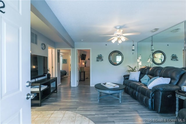 living room featuring visible vents, a ceiling fan, and wood finished floors