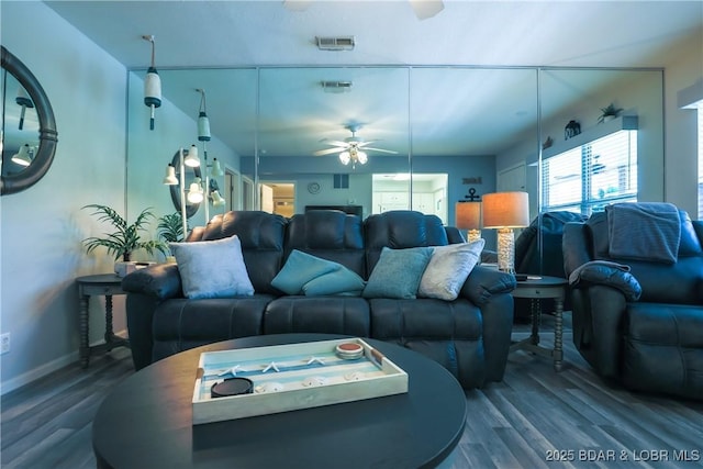 living room featuring visible vents, ceiling fan, baseboards, and wood finished floors