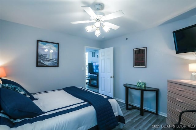 bedroom with a ceiling fan, baseboards, and wood finished floors