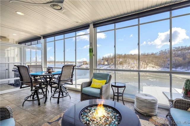 sunroom / solarium featuring a ceiling fan