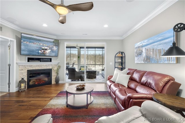 living room with crown molding, recessed lighting, visible vents, a stone fireplace, and wood finished floors