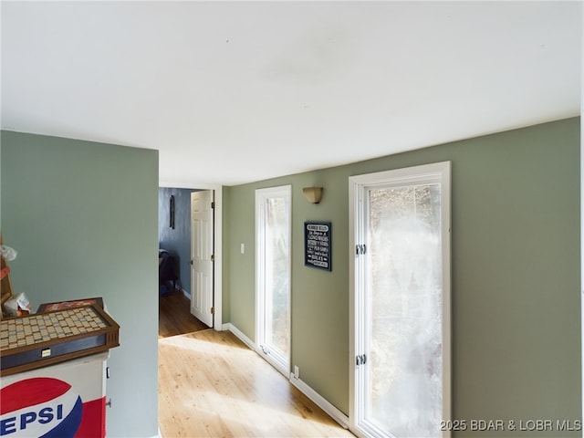 hall with light wood finished floors and baseboards