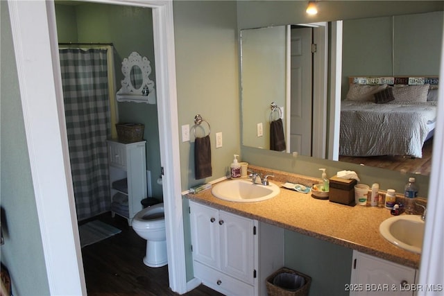 ensuite bathroom with a sink, ensuite bathroom, toilet, and double vanity