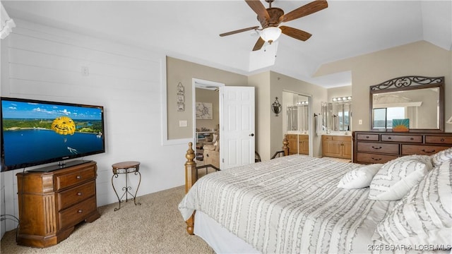 bedroom featuring light carpet, a ceiling fan, vaulted ceiling, and connected bathroom