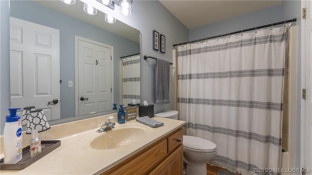 bathroom featuring toilet, a shower with shower curtain, and vanity