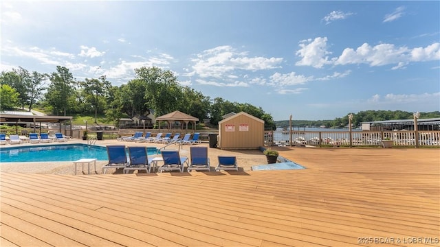 pool with a water view, fence, and a gazebo