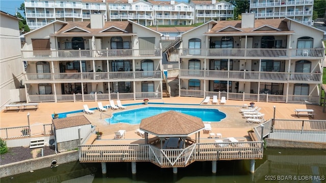 pool with a patio area and a water view