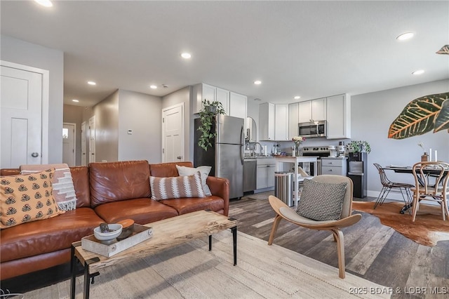 living room featuring baseboards, light wood-style flooring, and recessed lighting