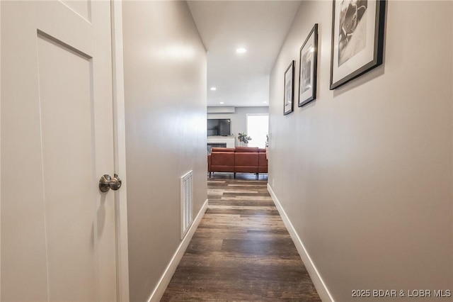 hallway featuring baseboards, visible vents, dark wood finished floors, and recessed lighting