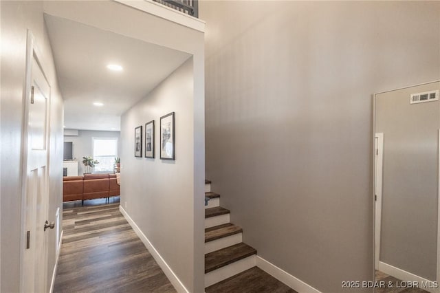 corridor with recessed lighting, dark wood-style flooring, visible vents, baseboards, and stairs