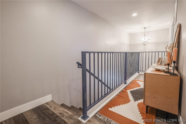 stairs with baseboards, recessed lighting, wood finished floors, and a notable chandelier