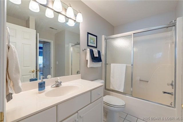 full bathroom with visible vents, toilet, combined bath / shower with glass door, vanity, and tile patterned flooring