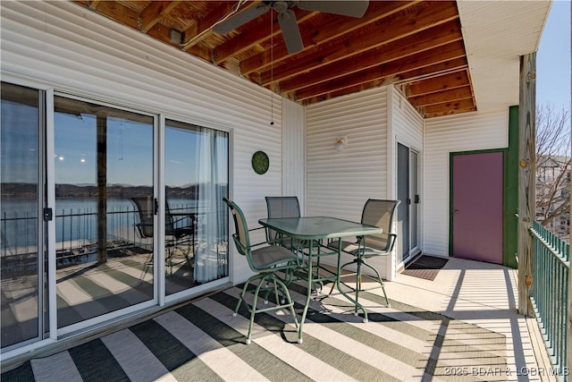 balcony with a water view and a ceiling fan