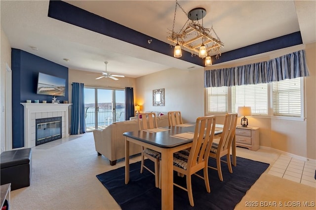 dining space with baseboards, a ceiling fan, a tile fireplace, tile patterned flooring, and carpet