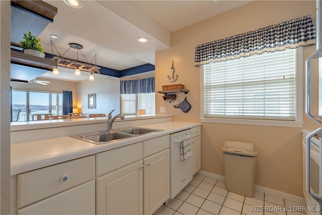 kitchen featuring a sink, a healthy amount of sunlight, white cabinets, and dishwasher