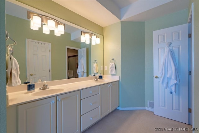 bathroom with double vanity, baseboards, visible vents, and a sink