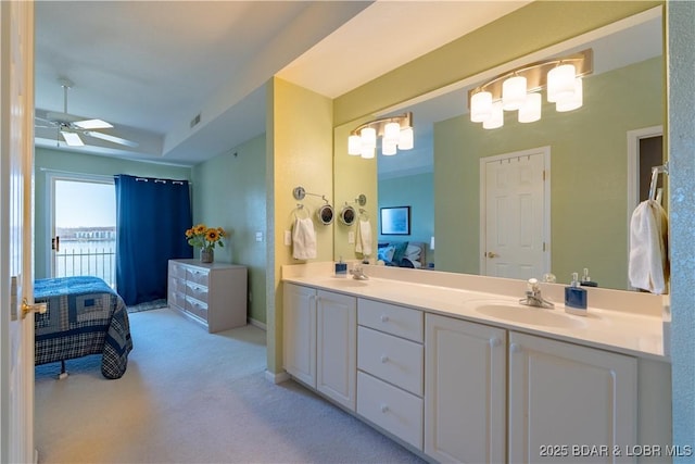 bathroom featuring ensuite bathroom, ceiling fan, a sink, visible vents, and double vanity