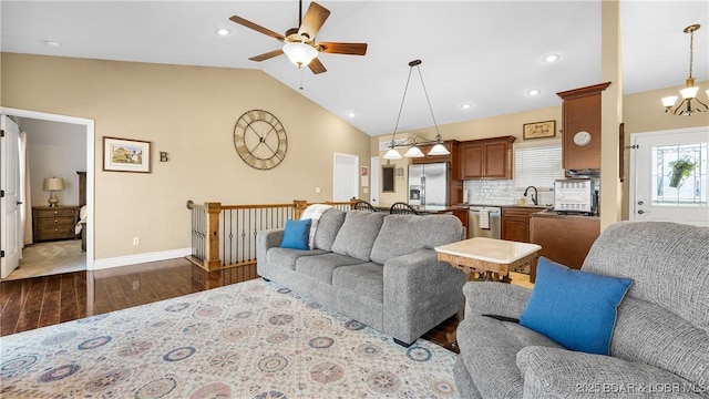 living room featuring dark wood finished floors, recessed lighting, vaulted ceiling, baseboards, and ceiling fan with notable chandelier