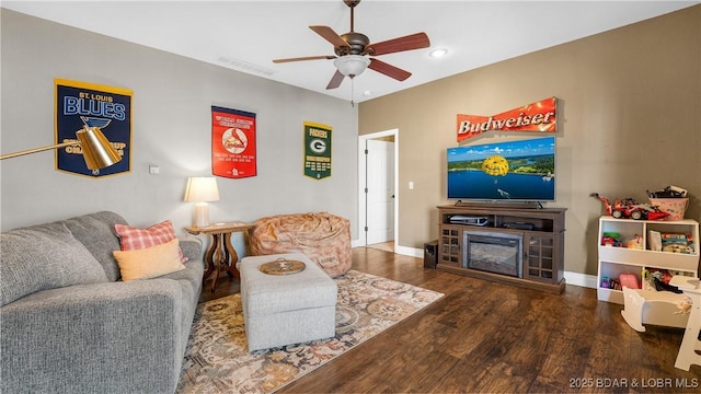 living room with baseboards, ceiling fan, visible vents, and wood finished floors