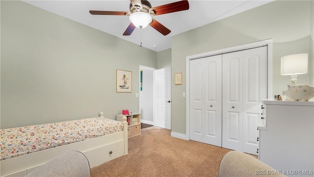 bedroom featuring a closet, light colored carpet, ceiling fan, and baseboards