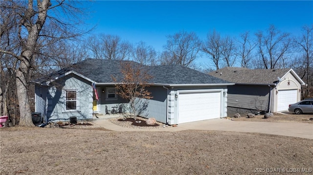 ranch-style home with concrete driveway, roof with shingles, and an attached garage