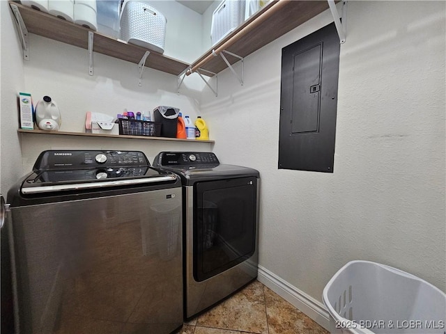 clothes washing area with laundry area, electric panel, baseboards, tile patterned flooring, and washing machine and dryer