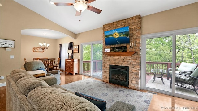 living room featuring visible vents, wood finished floors, ceiling fan with notable chandelier, and arched walkways