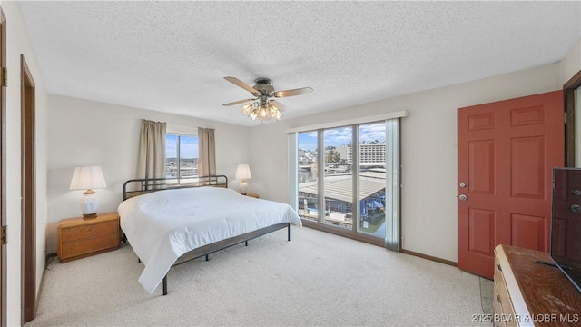 bedroom featuring a textured ceiling, light carpet, a ceiling fan, baseboards, and access to outside