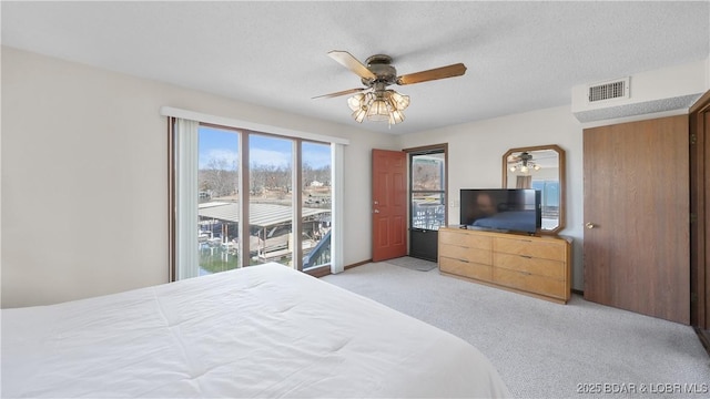 bedroom with light carpet, ceiling fan, a textured ceiling, and visible vents