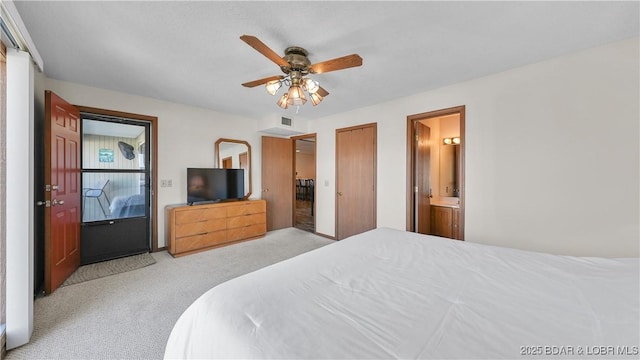 bedroom with ensuite bath, a ceiling fan, and light colored carpet