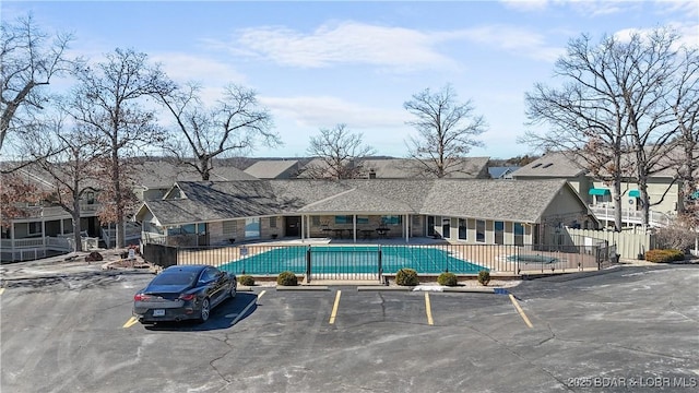 community pool with a patio and fence