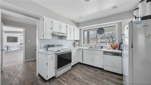 kitchen with white appliances, under cabinet range hood, white cabinets, and dark wood-style flooring