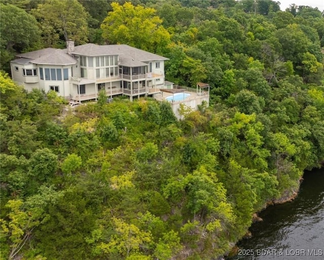 drone / aerial view featuring a water view and a view of trees