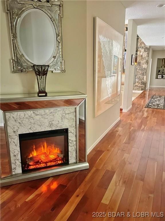 interior details featuring a fireplace, baseboards, and wood finished floors