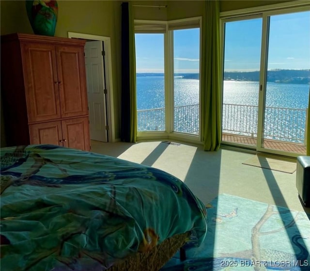 bedroom featuring a water view and access to outside