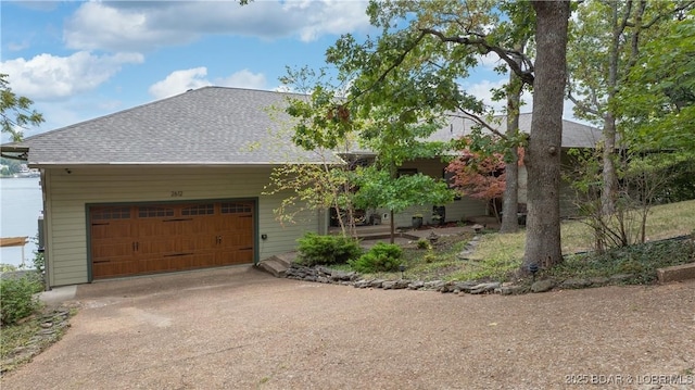 view of front of house with a shingled roof, concrete driveway, and an attached garage