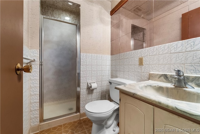 full bath featuring toilet, a stall shower, tile walls, and vanity