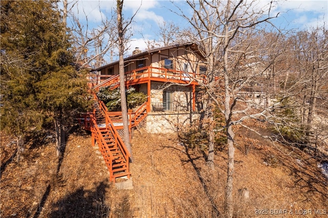 view of property exterior featuring a chimney and stairs