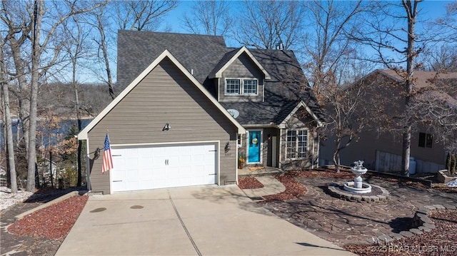 view of front of house featuring roof with shingles, driveway, and an attached garage