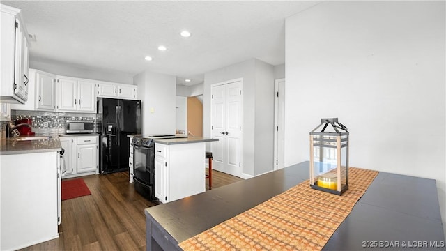 5317 Locust Ct, Osage Beach, MO 65065 - kitchen with black appliances, a sink, a kitchen island, recessed lighting, and dark wood-type flooring