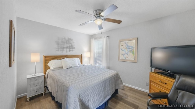 bedroom featuring ceiling fan, wood finished floors, and baseboards