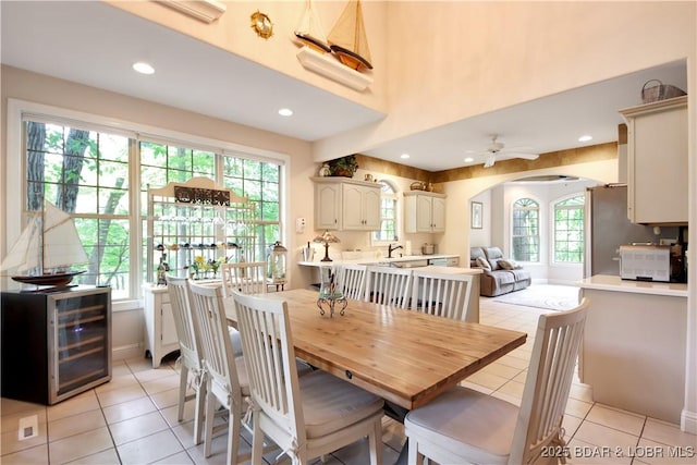 dining area with arched walkways, ceiling fan, recessed lighting, and light tile patterned floors