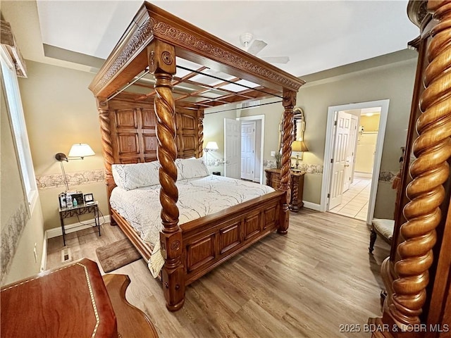 bedroom featuring light wood-style floors, baseboards, and ensuite bathroom