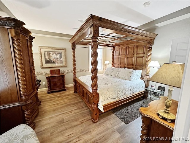 bedroom with light wood finished floors and baseboards